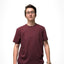 White person in maroon t-shisrt showing flat chest while wearing a binder.
