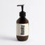 A dark amber brown pump bottle with a cream-colored label featuring the brand name 'Hunky' Body Serum - Scar Cream bold black text, set against a clean white background. 