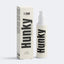 A bottle and matching box of Hunky T-Zone moisturizer, shown on a clean light gray studio background. For acne prone skin due to HRT