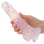Hand holding a white silicone product with colorful polka dots on a white background