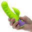 Hand holding a green and purple silicone tool on a white background