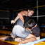 Two wrestlers in a match with a referee in the background one wearing the no. 1 singlet