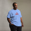 Person wearing a light blue t-shirt with 'I ❤️ TDYKES' text on a plain background