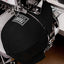 Black Trans checkered cap being embroidered on a machine.