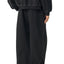 trans person wearing black contrast stitching sweatpants side