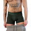 White person's torso wearing Dark Green Cake Bandit Monochrome 6" Boxer Briefs with grey sweatpants