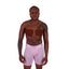 Black Person with binding tape on chest wearing size small pink Cake Bandit Monochrome 6" Boxer Briefs- white background