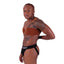 Side view of a hot black nonbinary trans person wearing the STP jockstrap by Cake Bandit